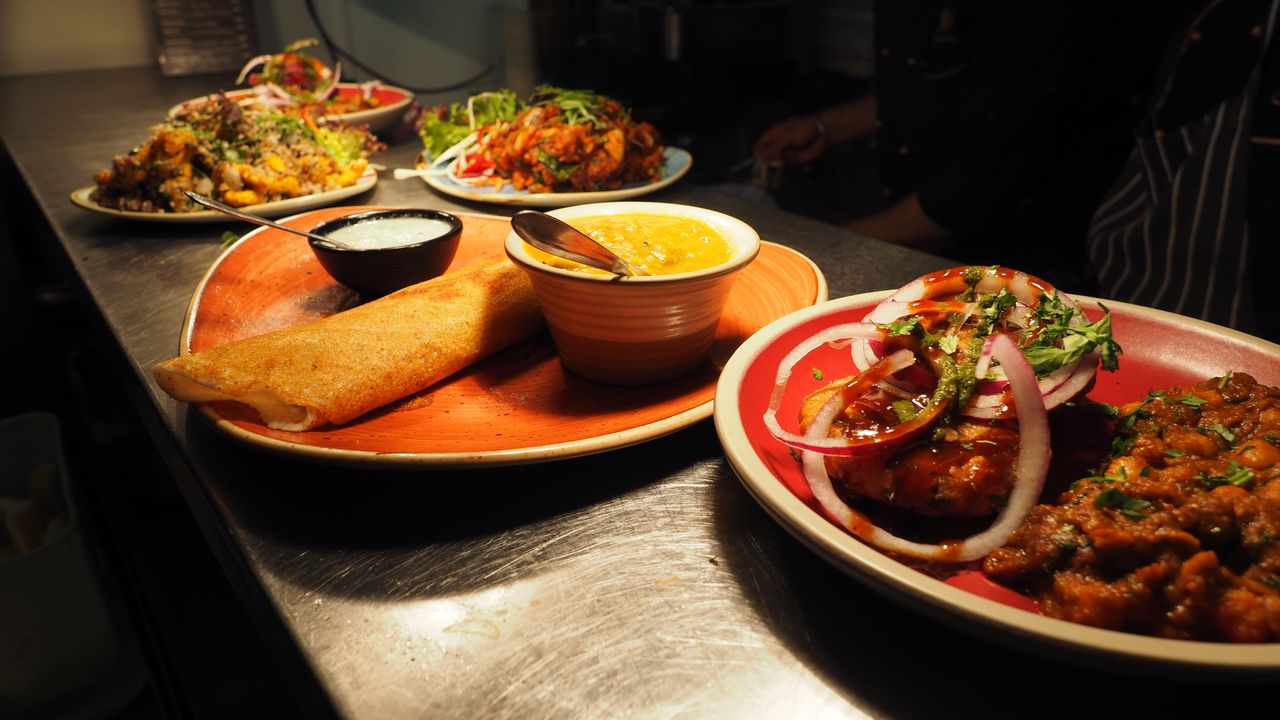 A table laden with Indian curries, breads and biryani